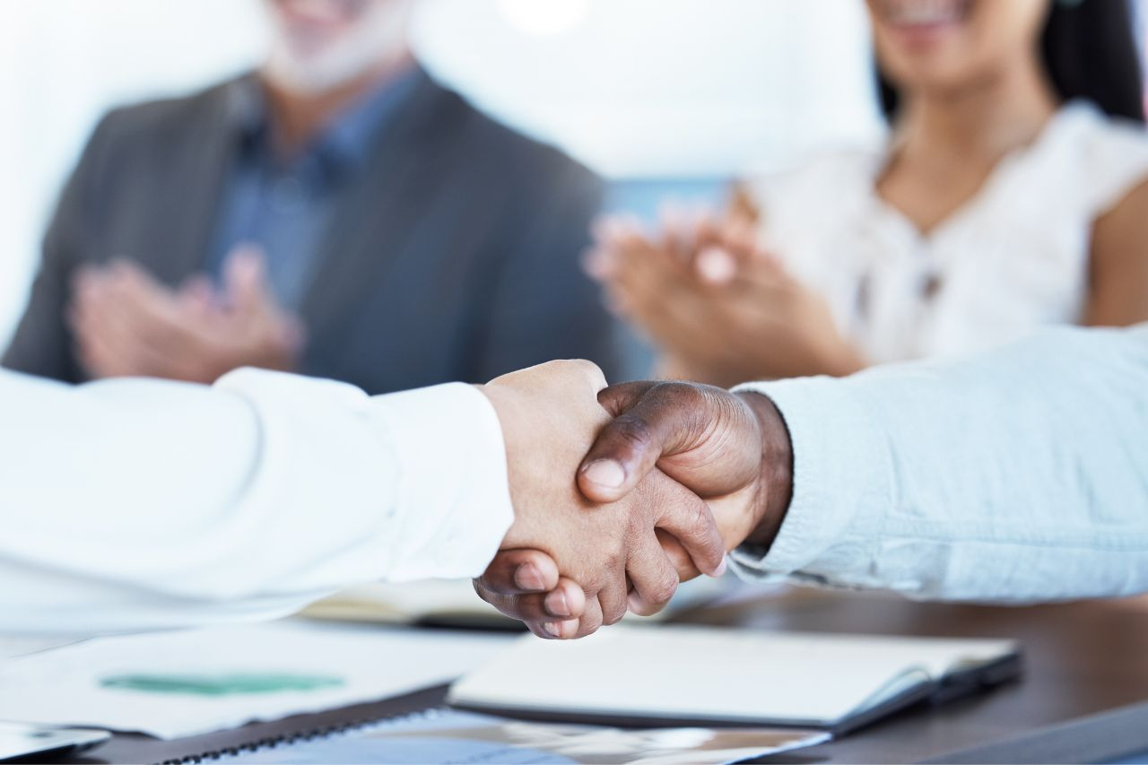 Two business people shake hands and complete a business deal.