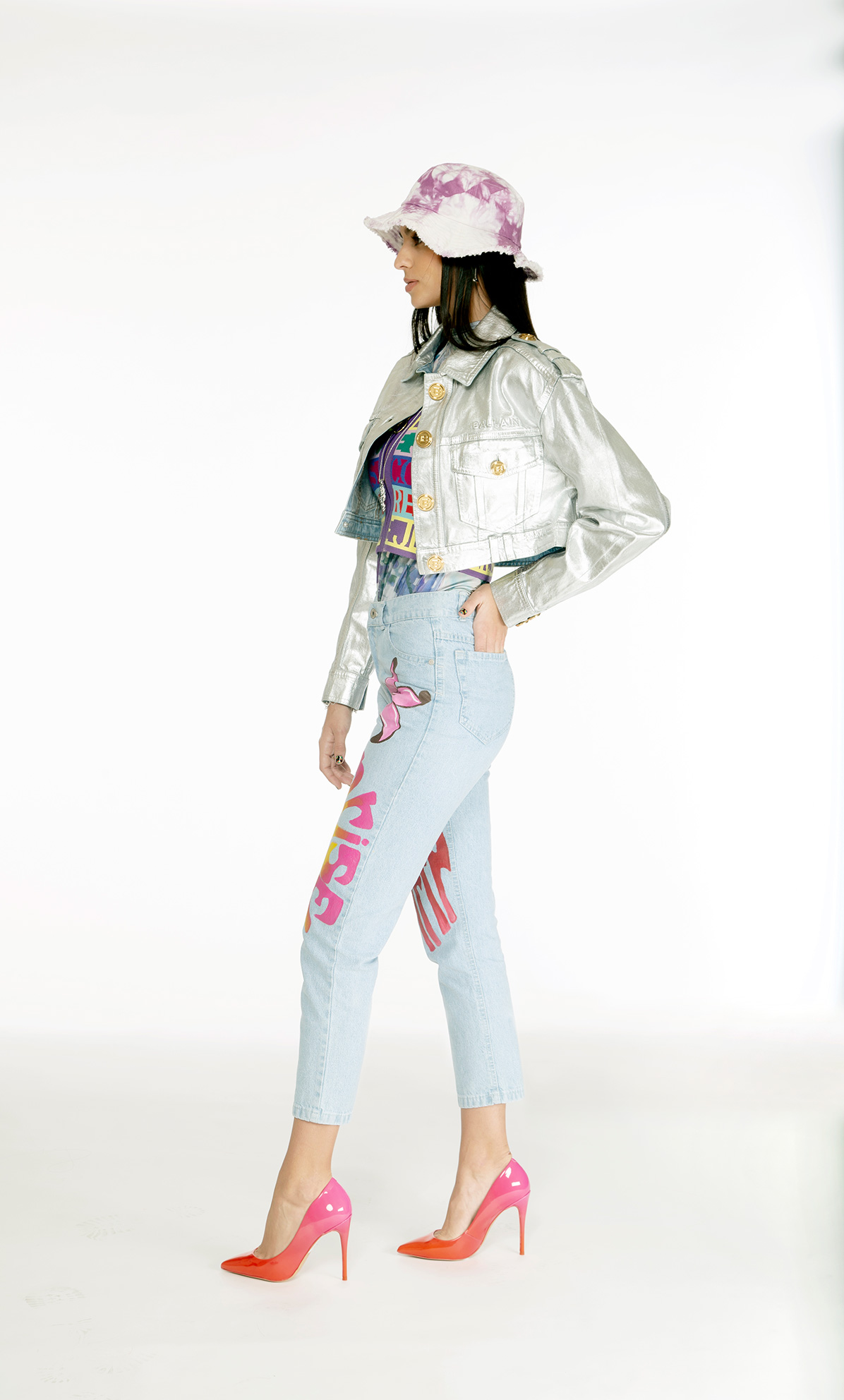 chamarra vaquera Balmain, playera con gráfico Desigual, top Versace Jeans Couture, jeans mom y sombrero bucket Wild & Alive, zapatillas Aldo, collar oso y pulsera carrusel Tous, pulsera Adolfo Dominguez, aretes y anillo de la colección bésame Tane - El Libro Amarillo