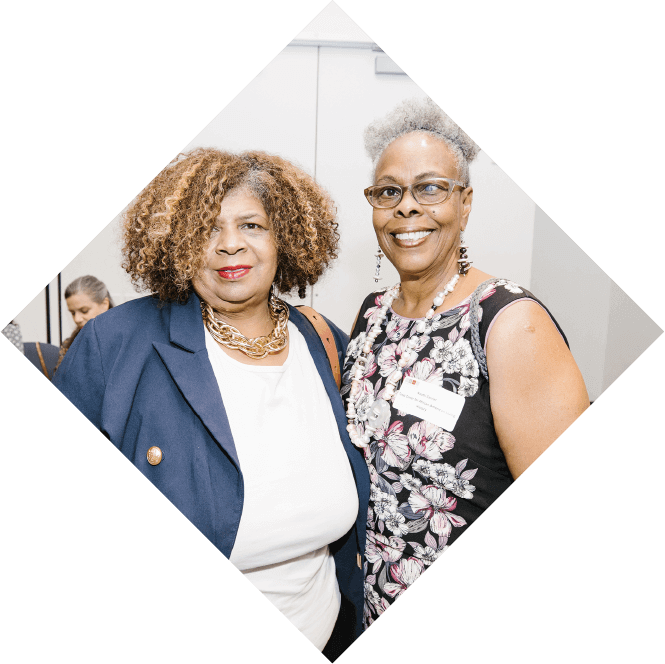Two women stand next to each other, pictured from the chest up