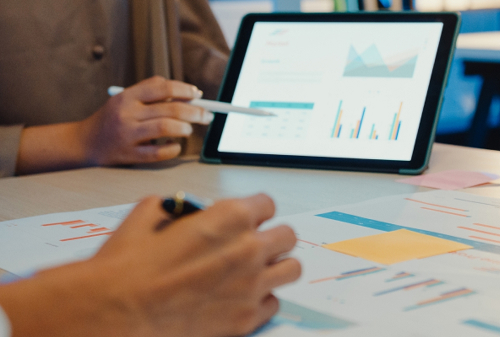 People discussing charts on screen and paper