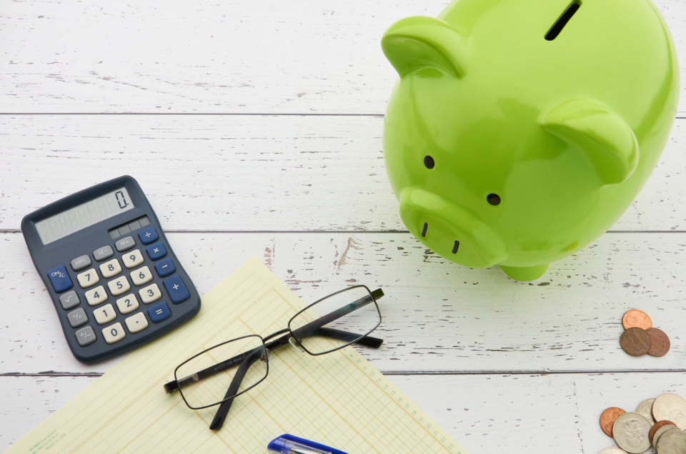 Green piggy bank with a calculator and glasses, a college savings concept