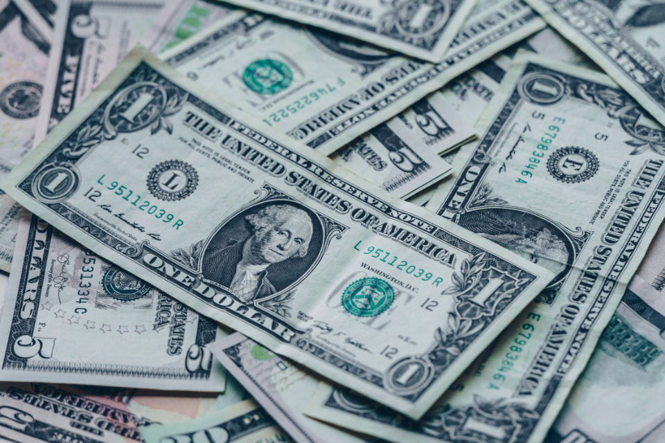 A spread of U.S. dollar bills, representing retirement savings and Roth contributions