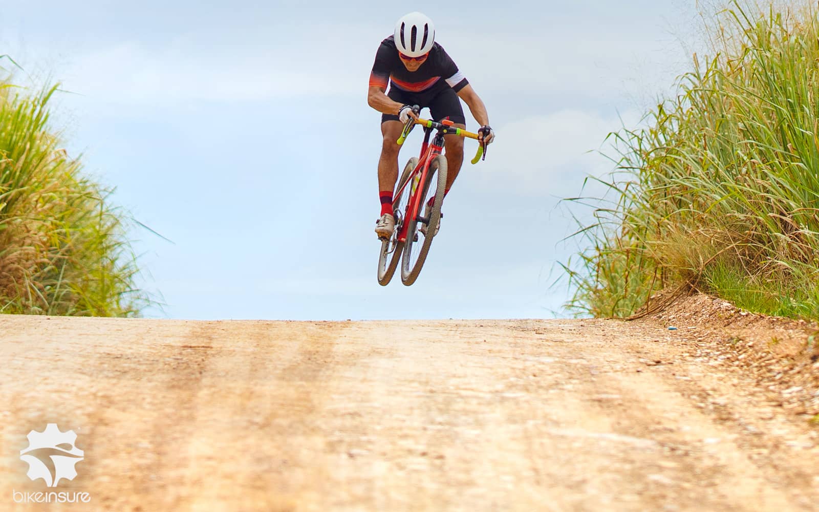 Cyclist jumping on a gravel road