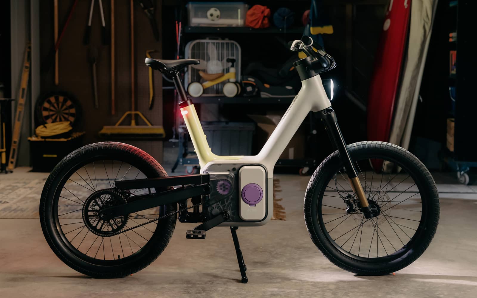 ALSO TM-B e-bike parked in a garage with its integrated headlight and red rear light illuminated.