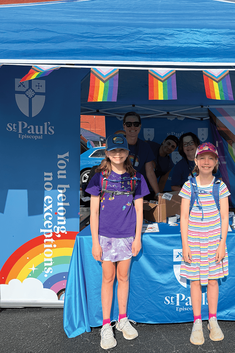 Family volunteering at a pride booth.