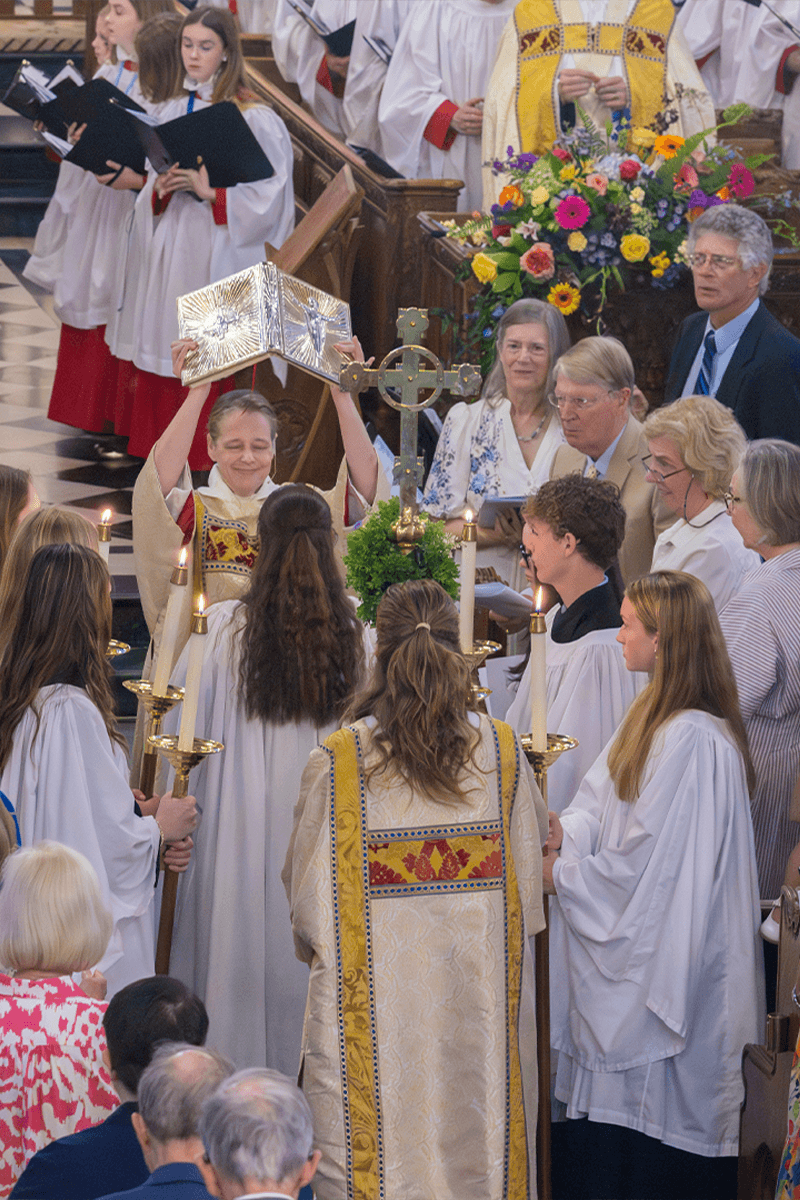 The Gospel Book being raised up in the middle of a full church.