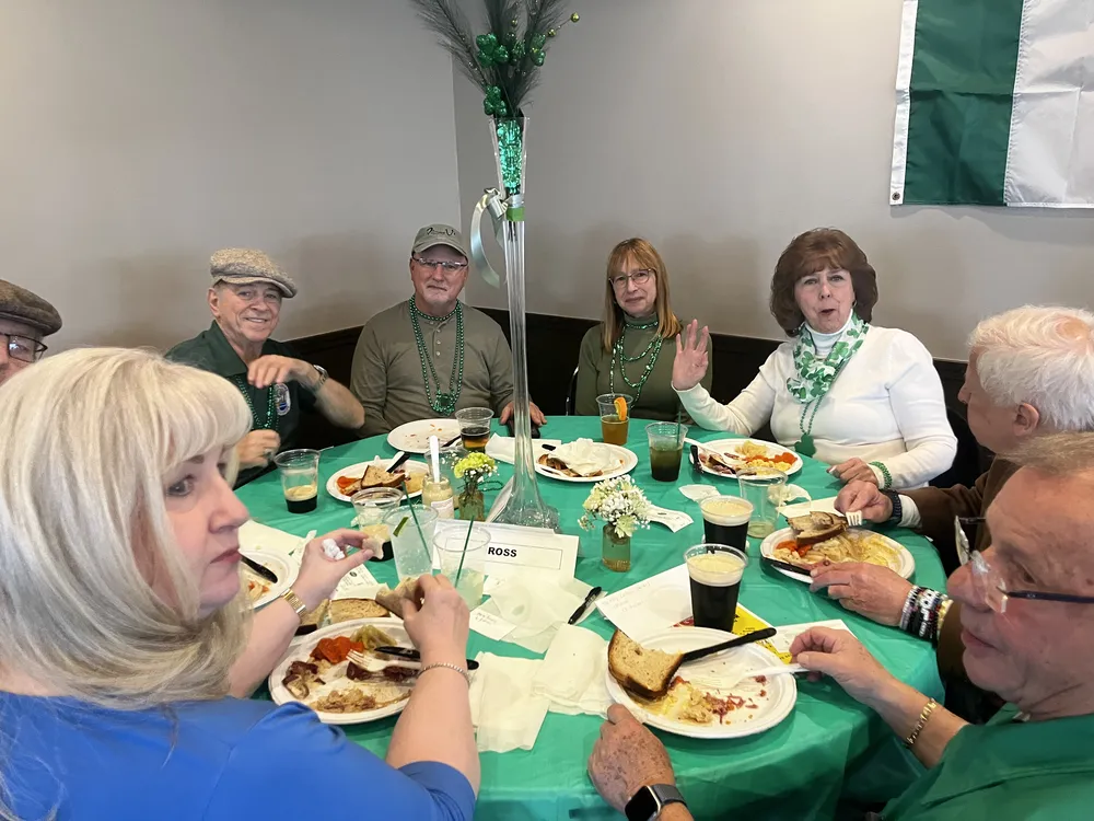 River Grove Lions Club members celebrating St. Patrick's Day at the dinner table during the annual club fundraiser