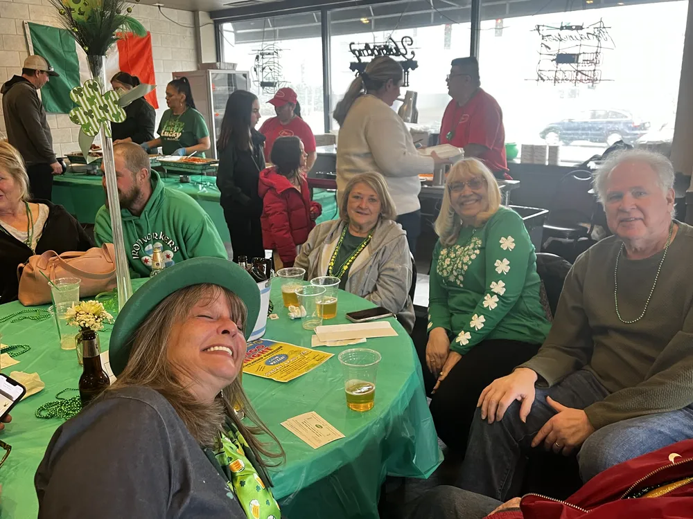 River Grove Lions Club members sharing a festive St. Patrick's Day moment together at the community fundraiser dinner