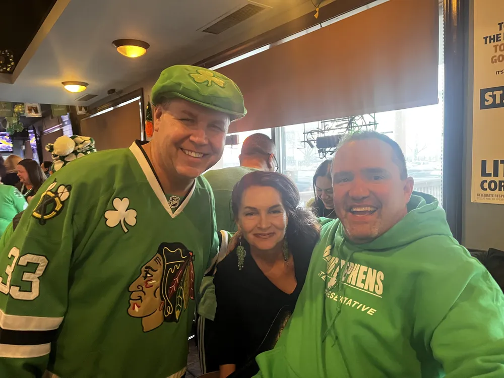 River Grove Lions Club members smiling together in festive green during the St. Patrick's Day dinner celebration