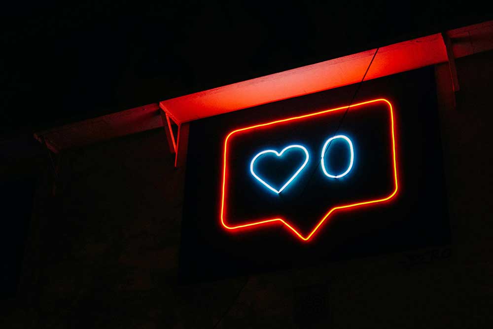 Neon sign that looks like a red Instagram notification for likes. The text inside the sign indicates that there are no new likes on a post.