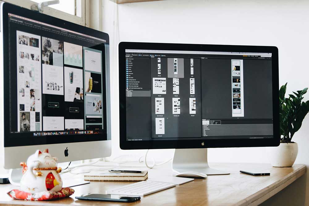 Two desktop computers. The screens of the computers show a variety of different graphics.