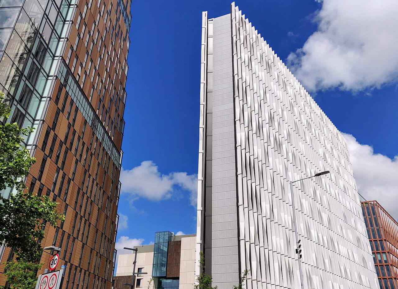 The buildings from the Wood Lane/Westway underpass entrance to Imperial College London's new White City North Campus. On the right is the Sir Michael Uren Biomedical Engineering Research Hub and on the left is 88 Wood Lane, a residential development. In the background is the Molecular Sciences Research Hub, a chemistry research laboratory.