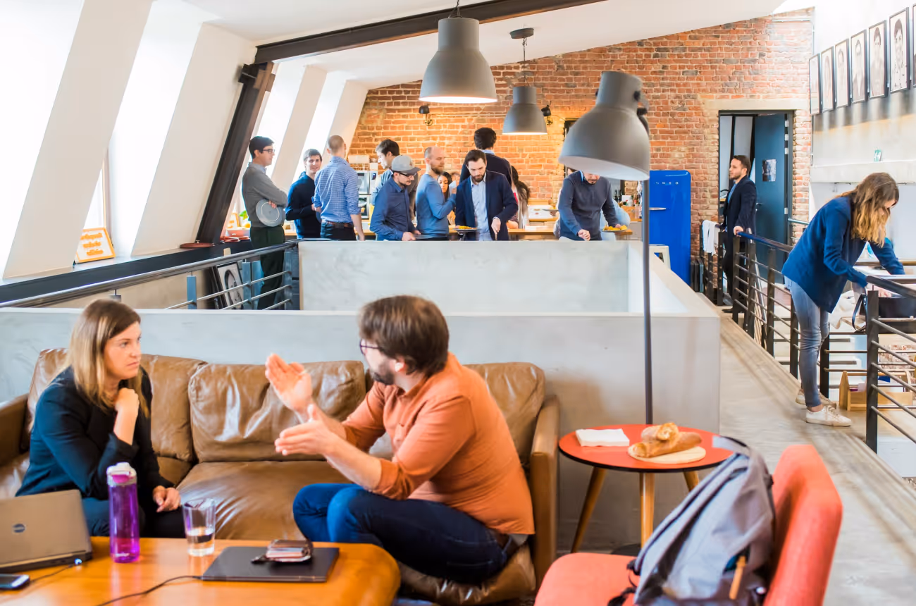 Modern workplace collaboration with employees engaging in feedback discussions and team interactions in a vibrant office setting.