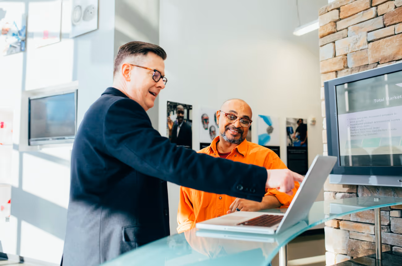 Two employees discussing workplace feedback data to improve employee sentiment and internal communications.