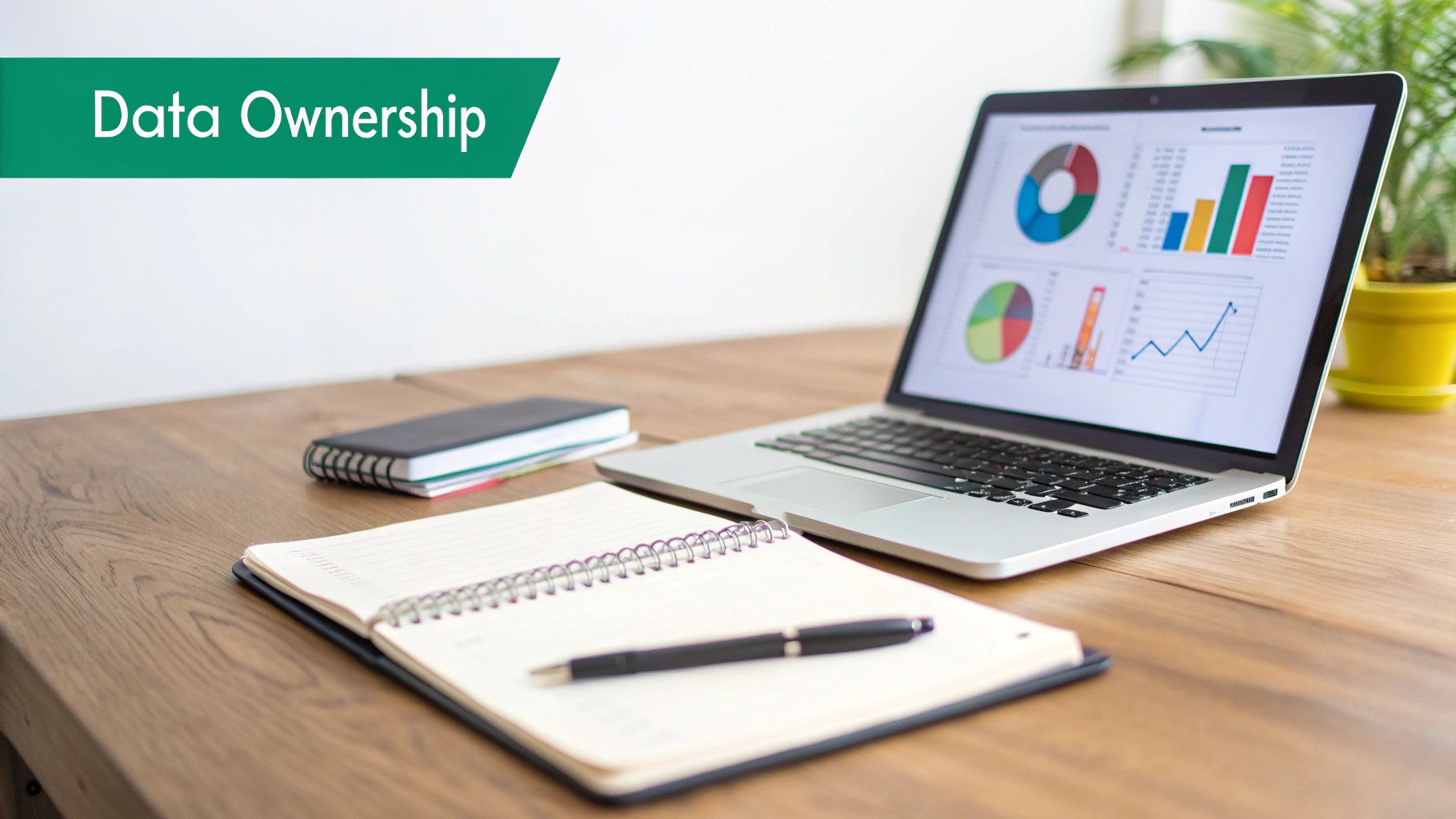 A laptop screen displays charts and graphs about 'Data Ownership' next to a notebook and pen.