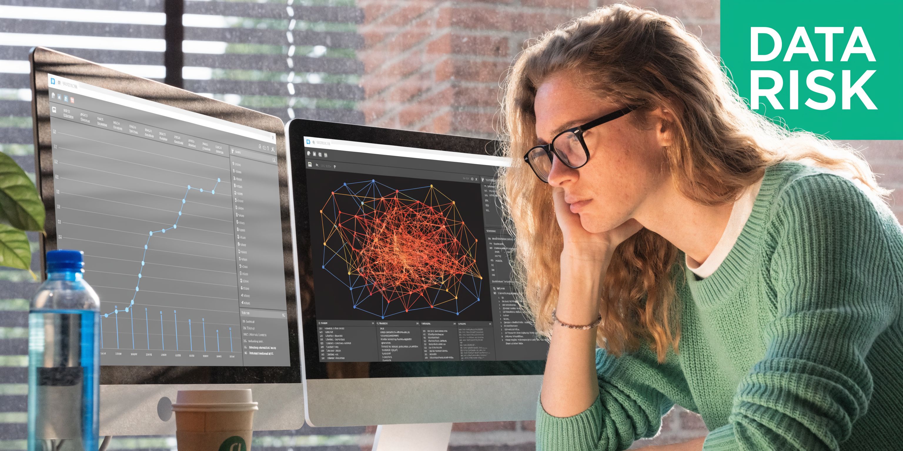 A focused woman analyzing complex data visualizations and network graphs on two computer screens in an office.