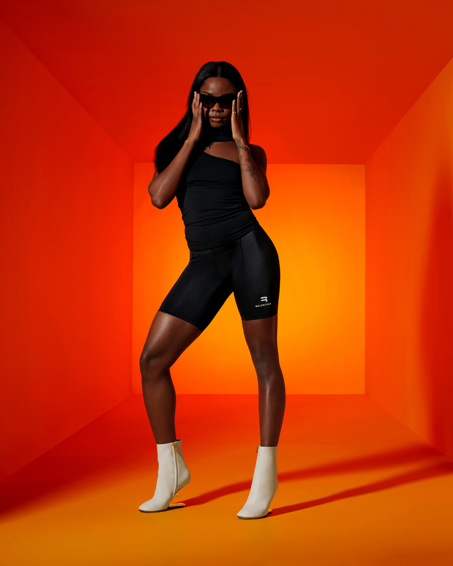 Woman in black with orange background