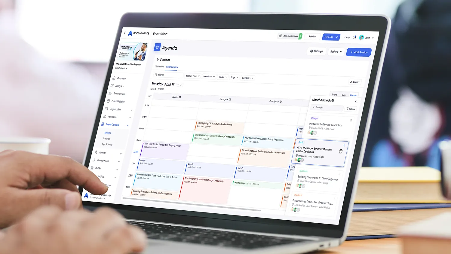 Alt-image text: Screenshot of an event agenda builder showing tracks and sessions being dragged to new timeslots with conflicts resolved in real time