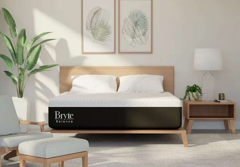 A bedroom with a Bryte Balance mattress with light shining through the window