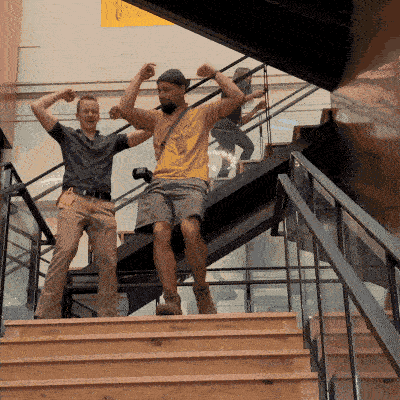 Two people dancing down the stairs in celebration