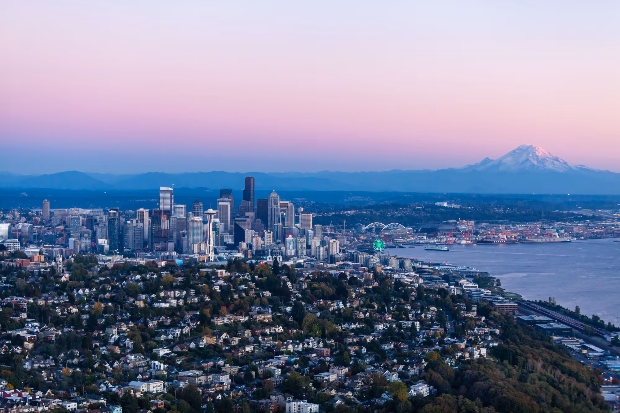 Helicopter aerial of downtown Seattle and Mount Rainier at sunset