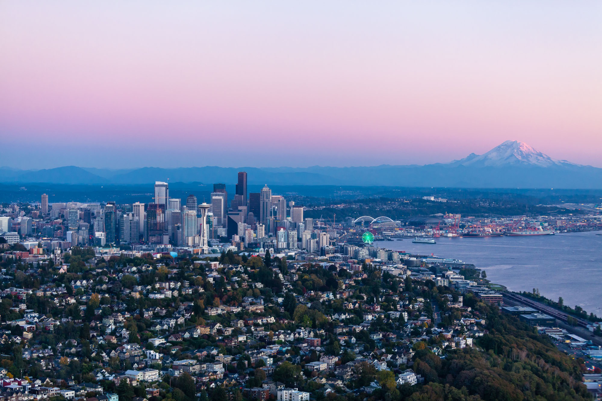 Helicopter aerial of downtown Seattle and Mount Rainier at sunset