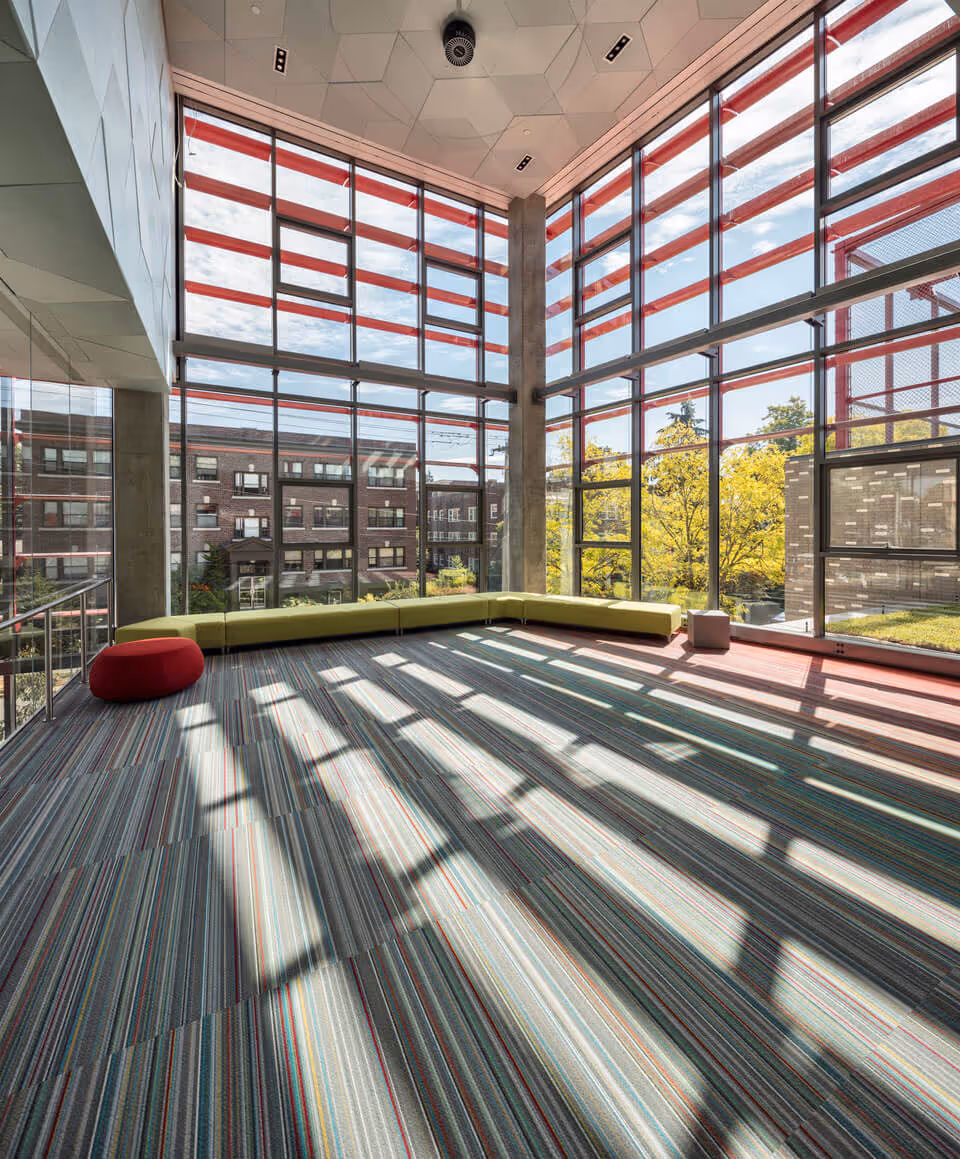 A view looking outward from a soaring room with two glass walls