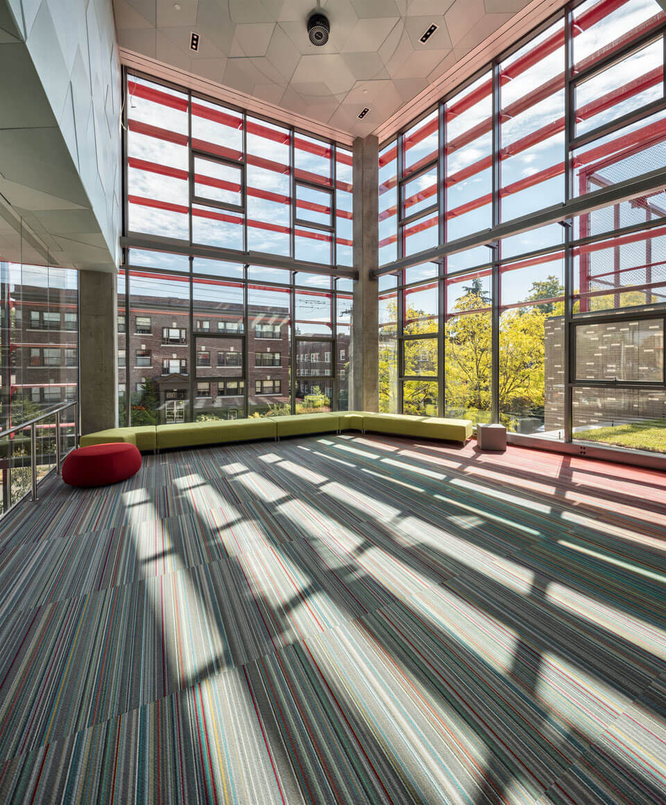 A view looking outward from a soaring room with two glass walls
