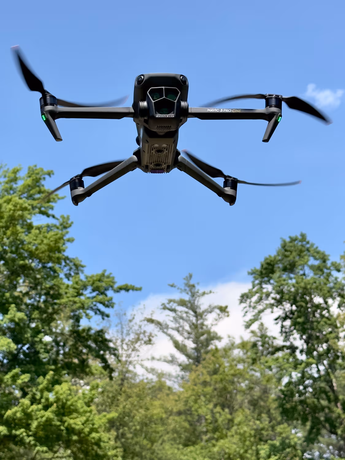 A drone hovering overhead against a blue sky