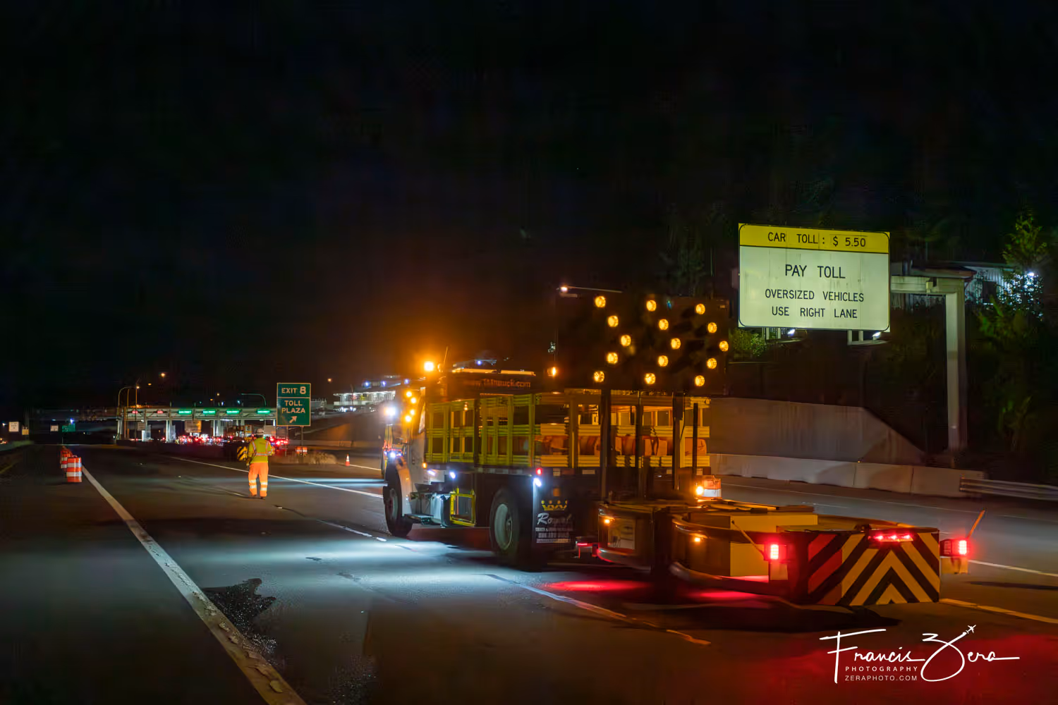 Construction workers setting up traffic barracades on a freeway