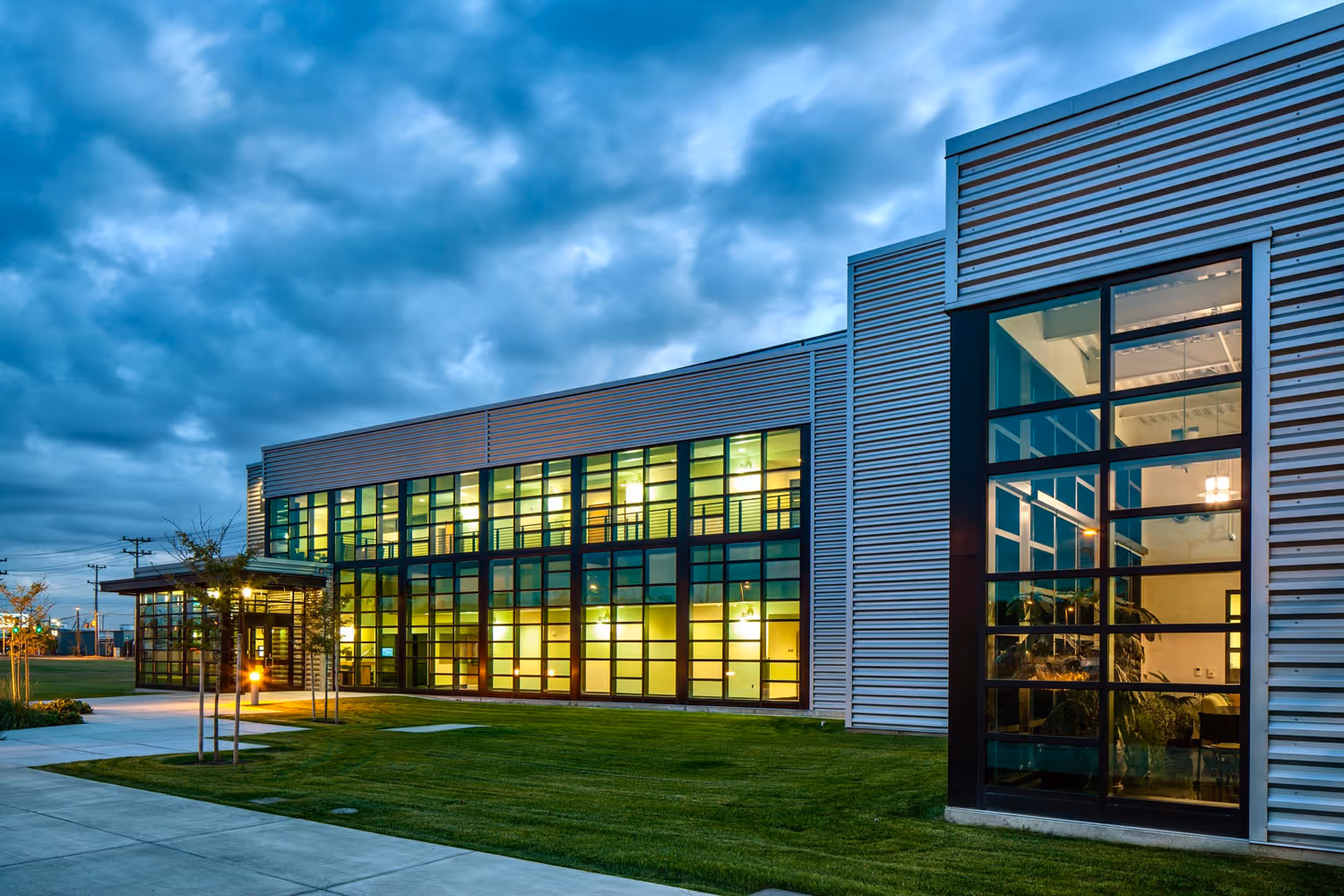 An exterior of a contemporary college building at twilight on a cloudy day