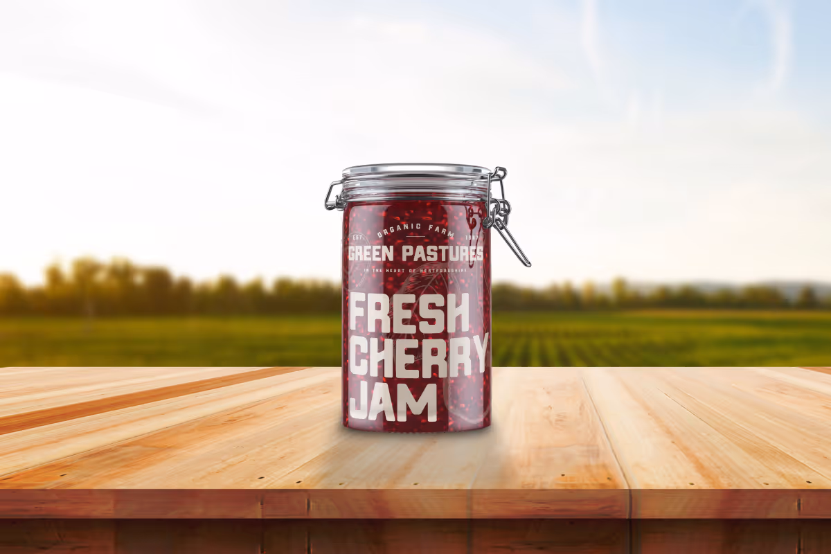 jam packaging design for pure delights. jar of fresh cherry jam sat on a table in a field