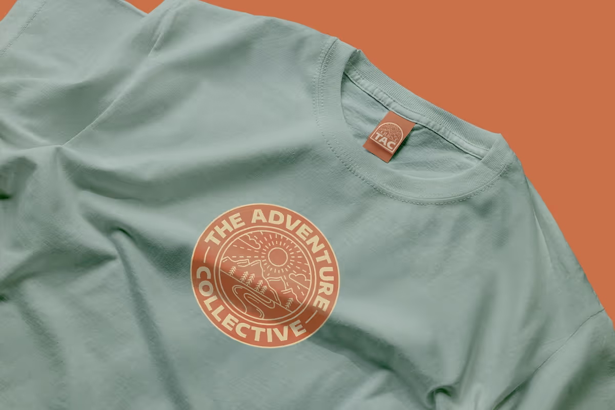 a t shirt design for the adventure collective. image is a blue hoodie with the primary logo in orange