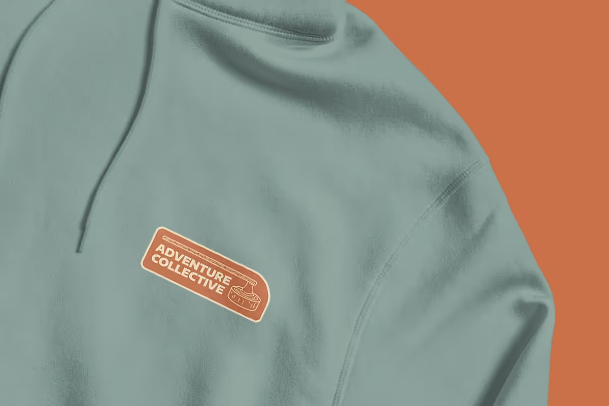 a hoodie design for the adventure collective. image is a blue hoodie with an orange design
