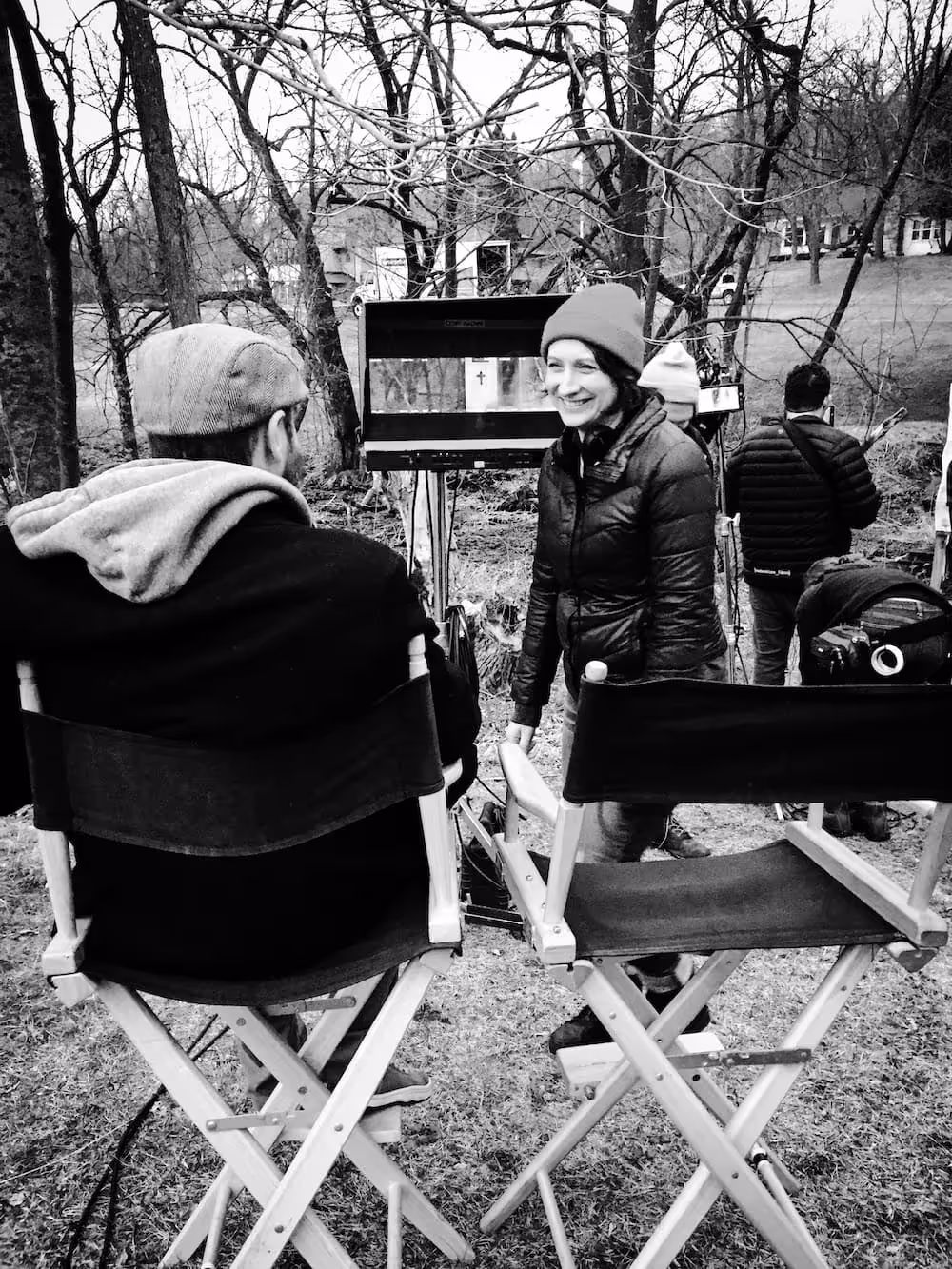 Film crew on location in winter, director's chairs in snowy wooded setting