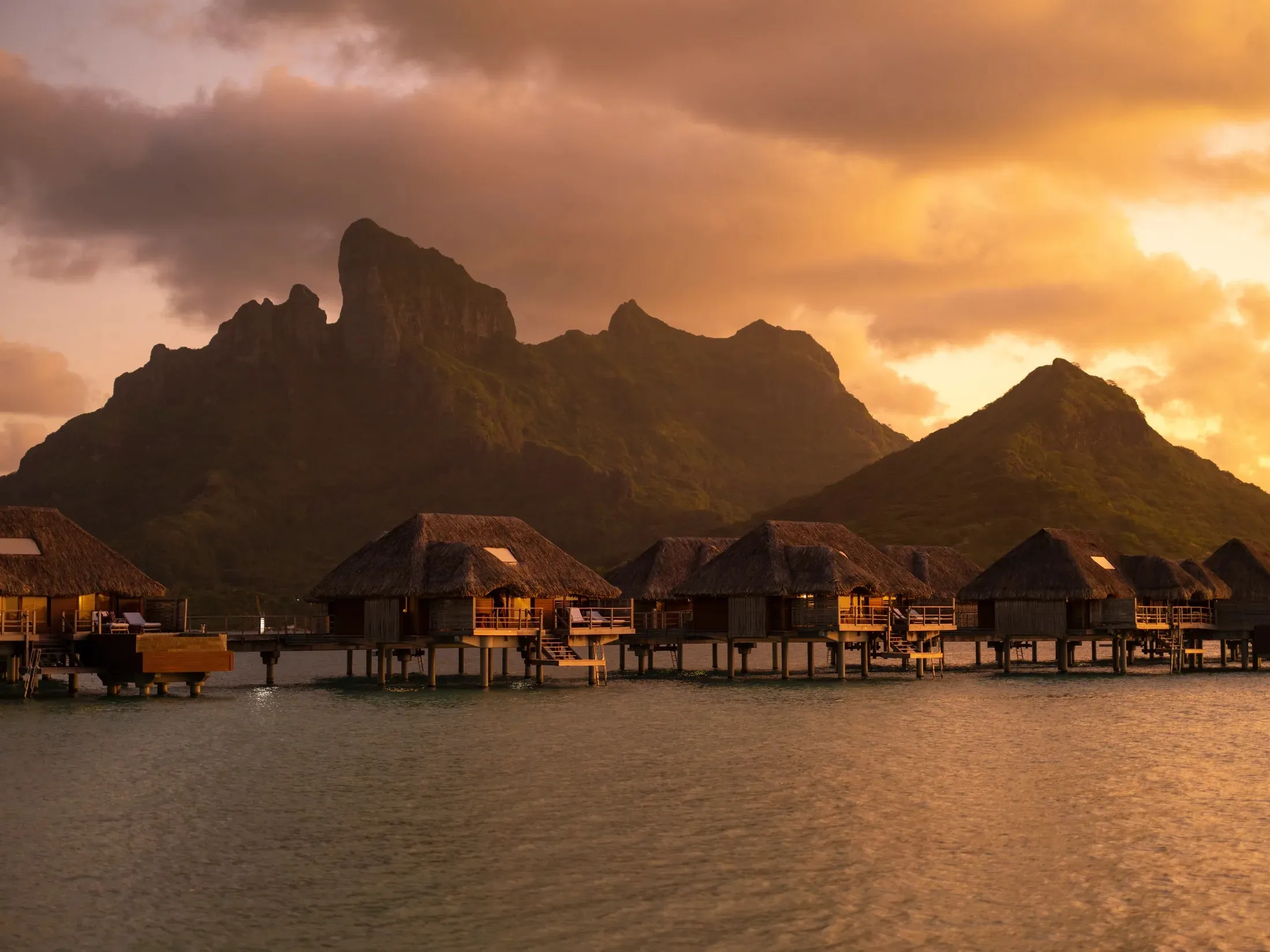 Overwater bungalows below Mount Otemanu at golden hour, Four Seasons Bora Bora