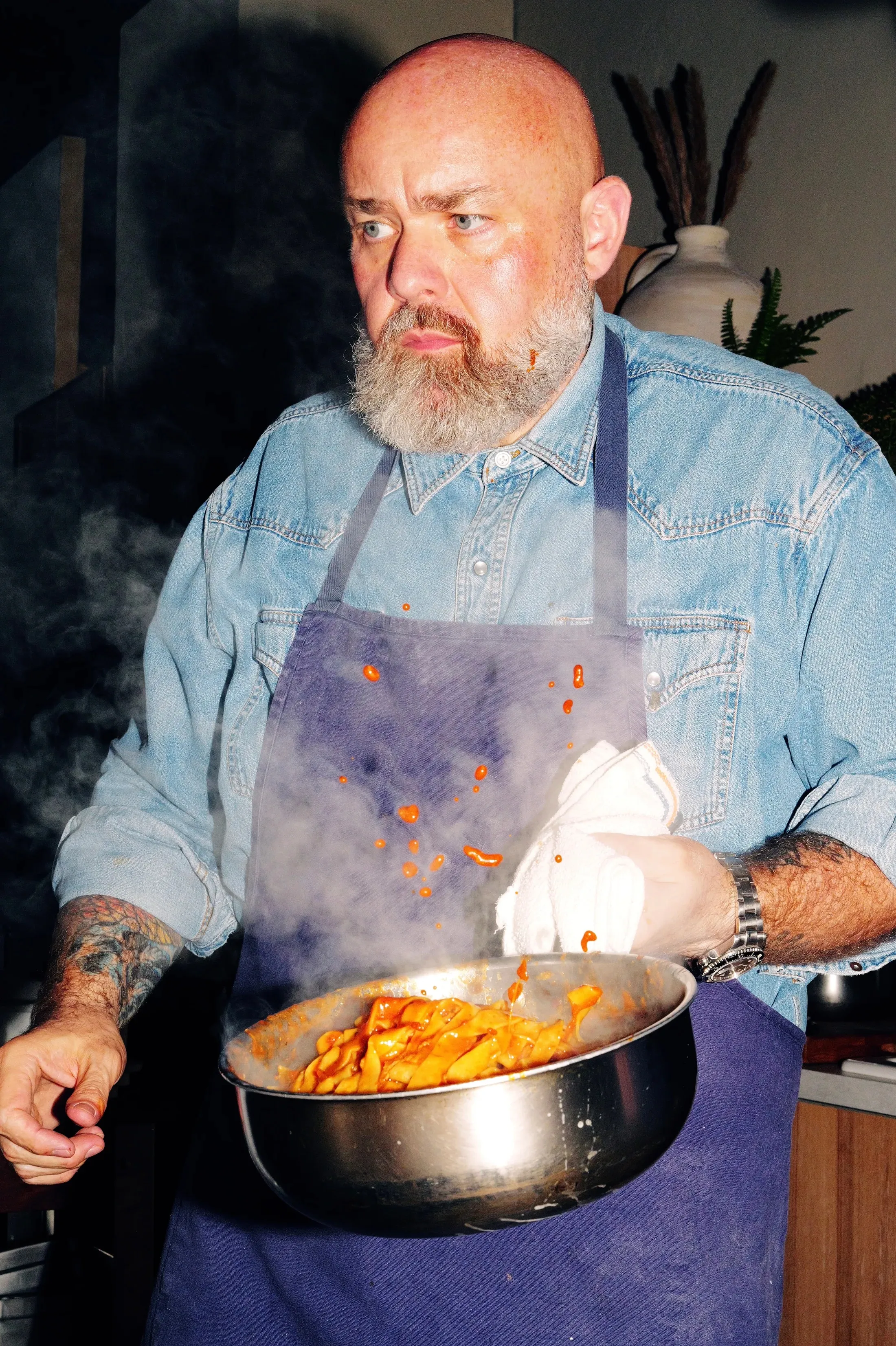 Chef finishing a pan of pasta over open flame at Lele Dinner Club