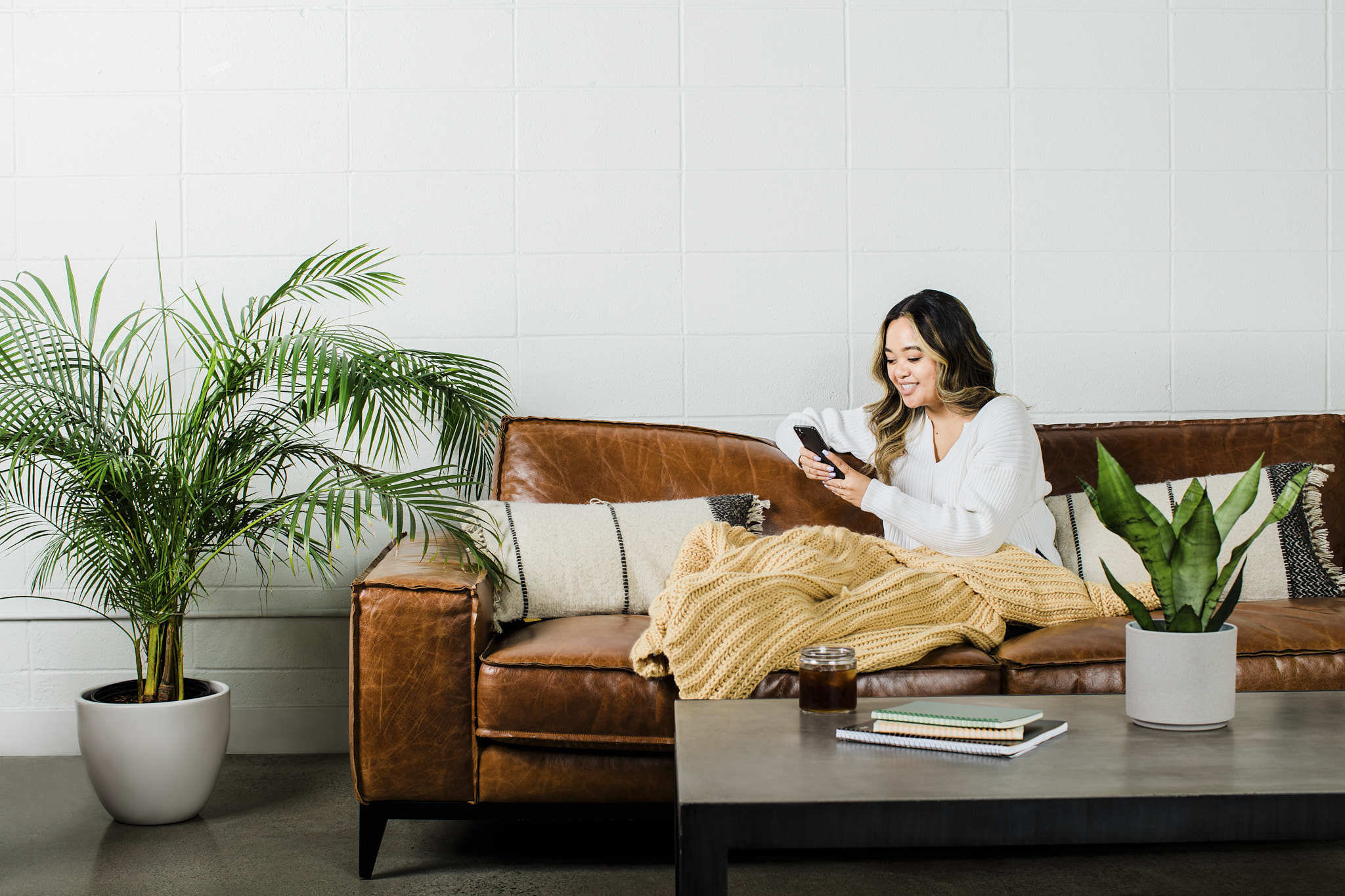Photo of a woman taking work calls from a comfy couch