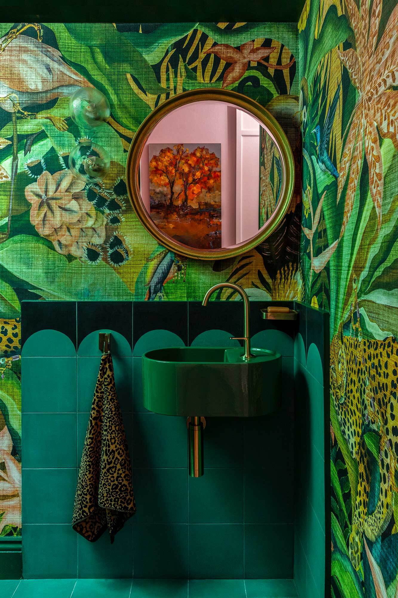 Élitis Paradise Jungle wallpaper, a green Cielo sink, brushed brass tapware and playful cement tiles