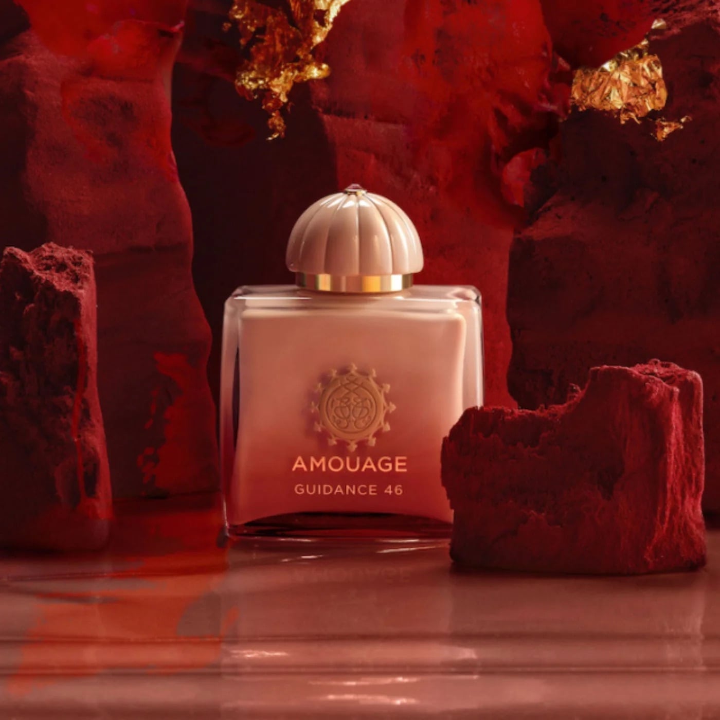 Flacon de parfum Amouage sur un fond de pierre rouge