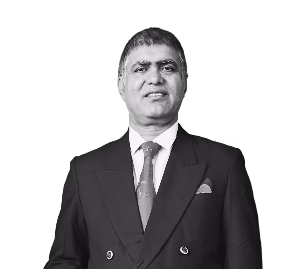 Portrait of a middle-aged man wearing a dark double-breasted suit, patterned tie, and pocket square, smiling slightly.