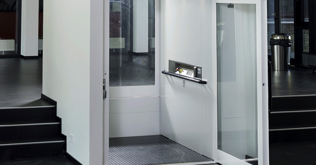Monochromatic  platform lift installed next to black staircase