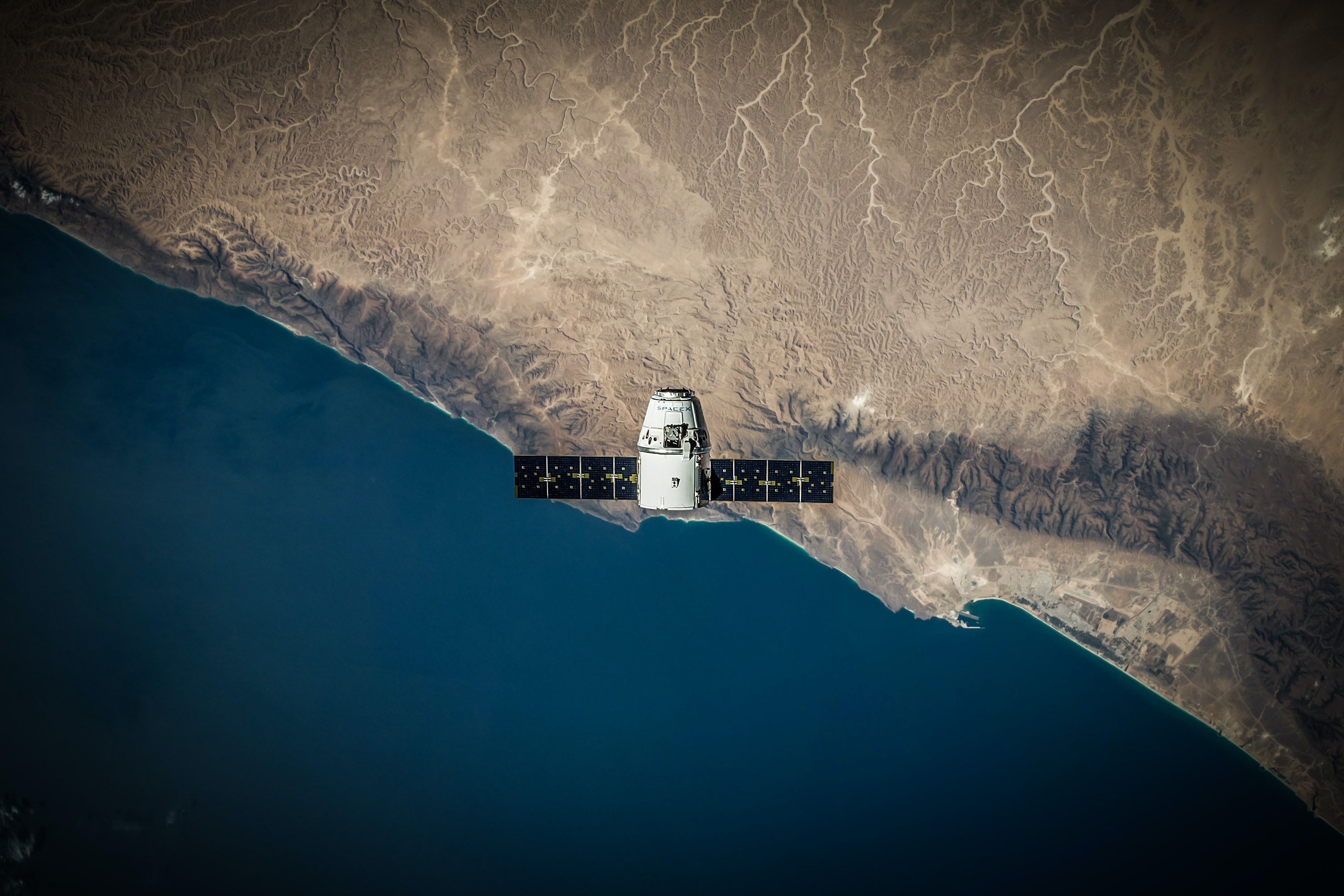 A satellite viewed from the top crossing from ocean to land