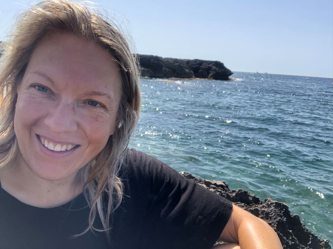 Frau genießt einen ruhigen Sommerabend am Wasser und verbindet sich wieder mit ihrem Körper