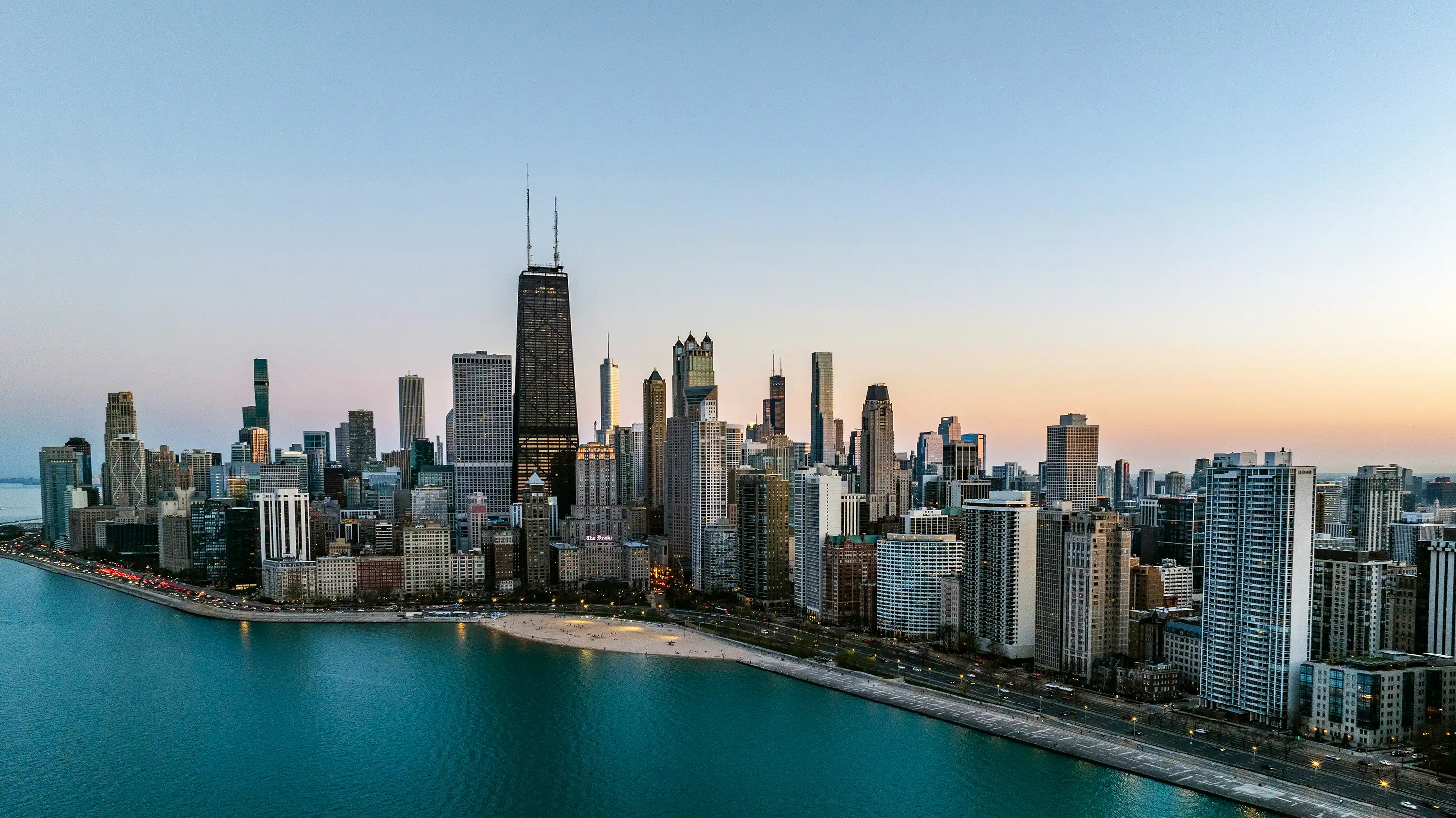 Chicago skyline and Lake Michigan shoreline at dusk seen from above North Avenue Beach