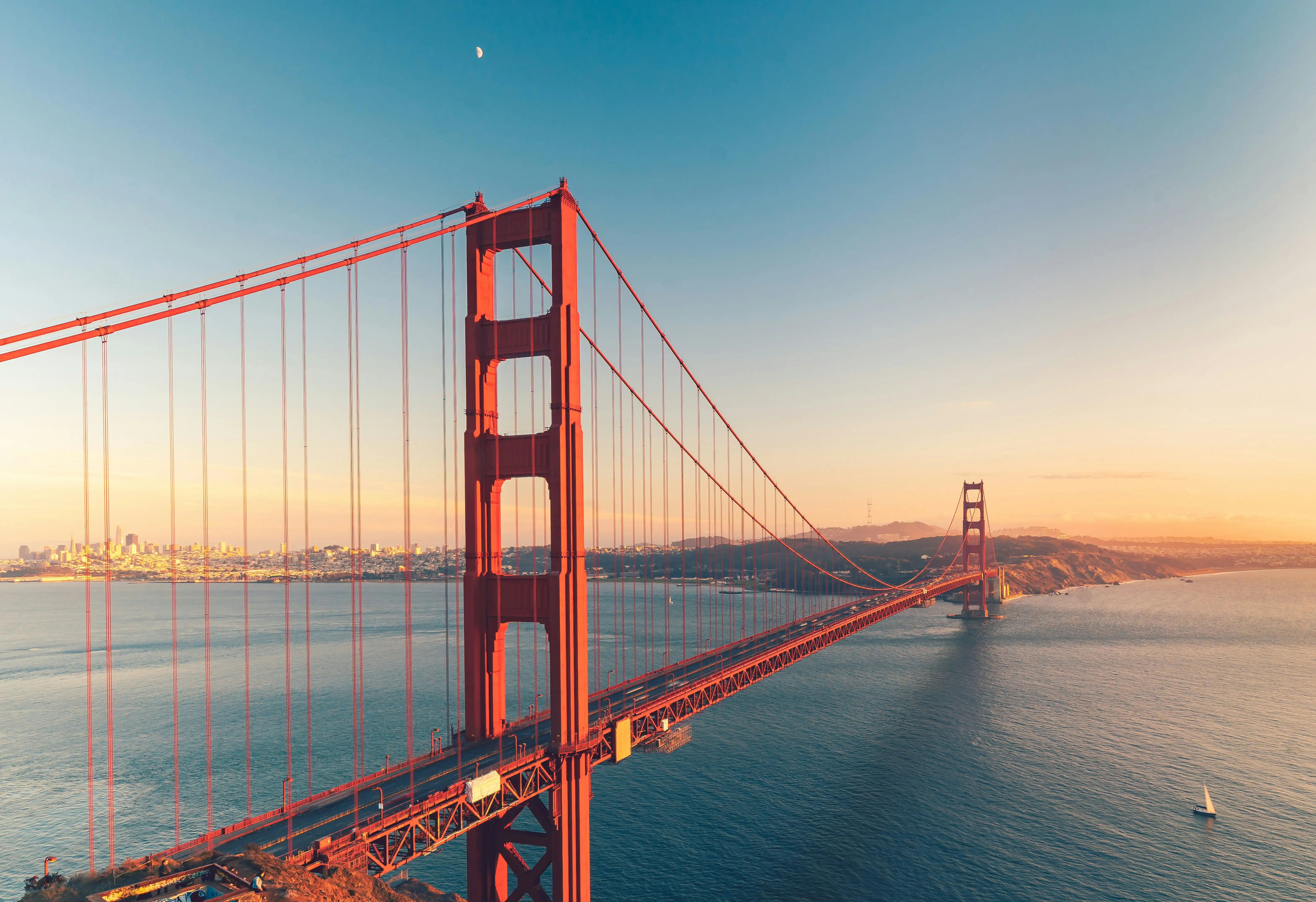Golden Gate Bridge at sunset with the San Francisco skyline in the distance
