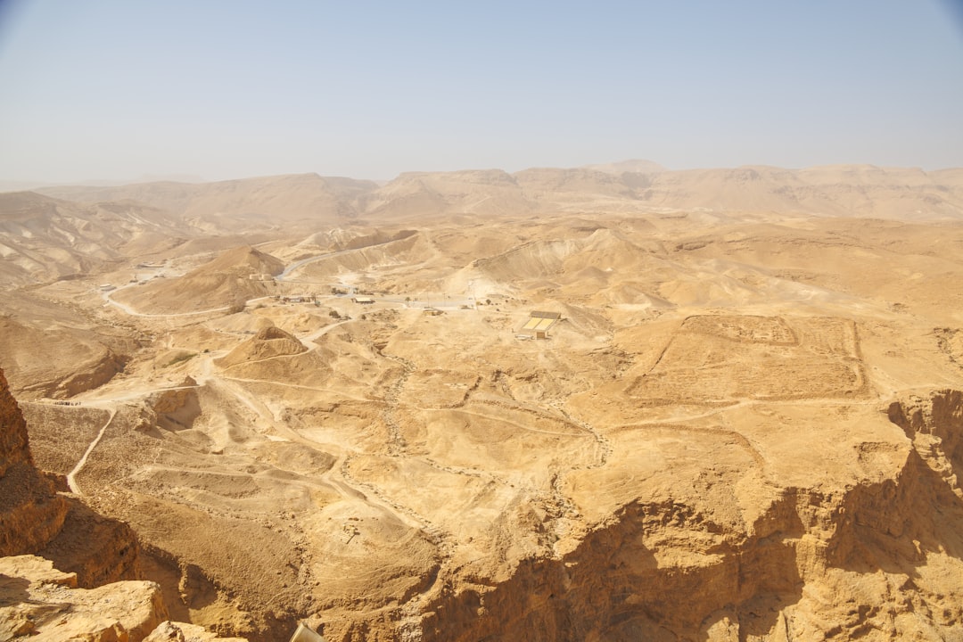 Arid desert landscape with ancient ruins and clear sky