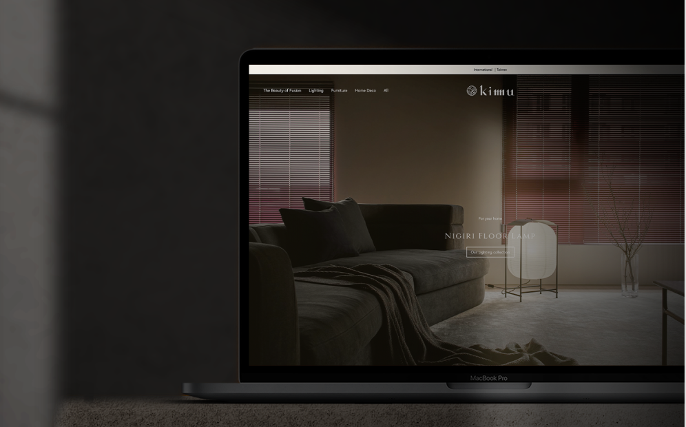 MacBook Pro displaying a living room with a dark sofa, a lit modern floor lamp, and window blinds.