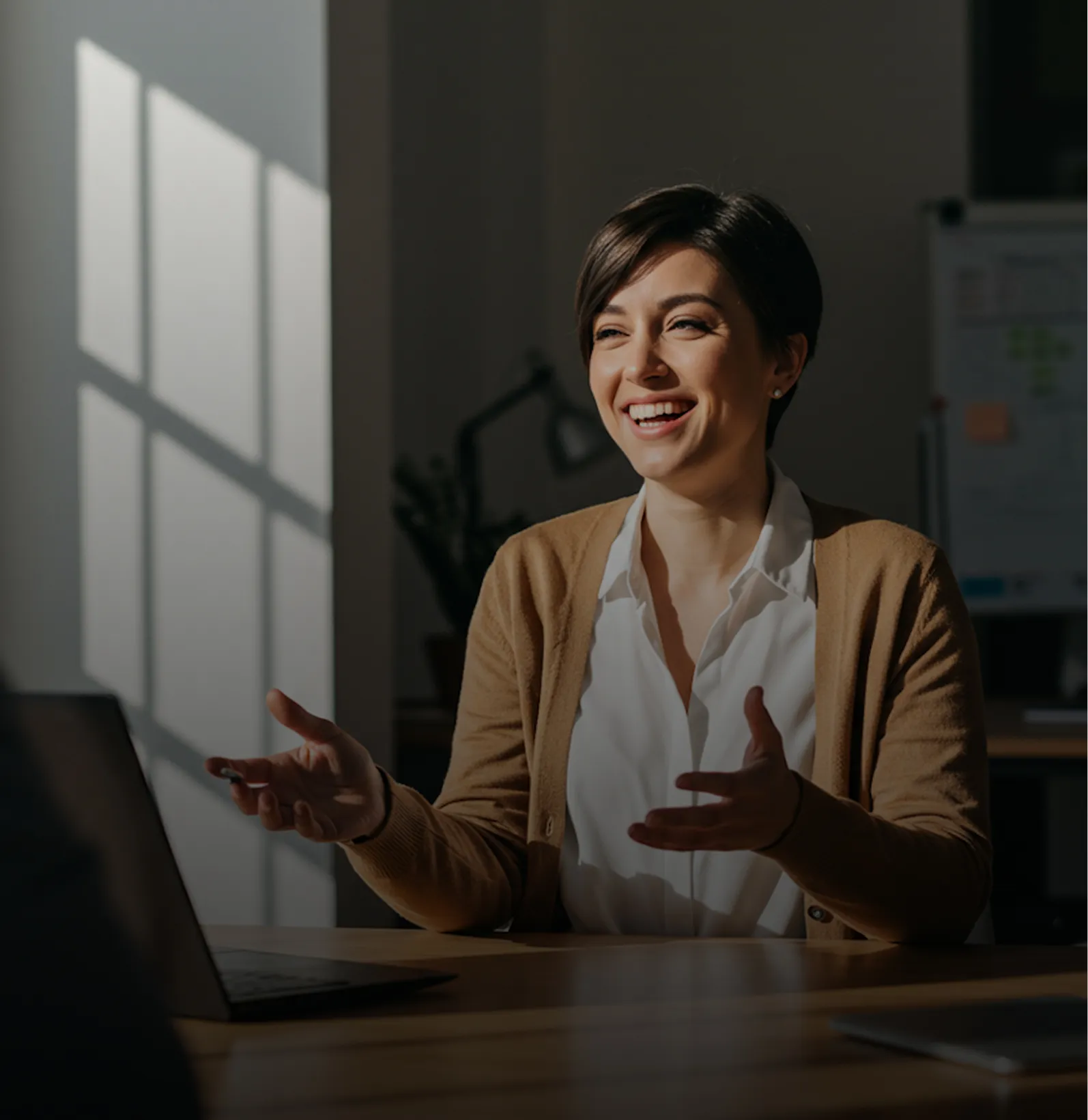 A woman sitting at a table with a laptop.