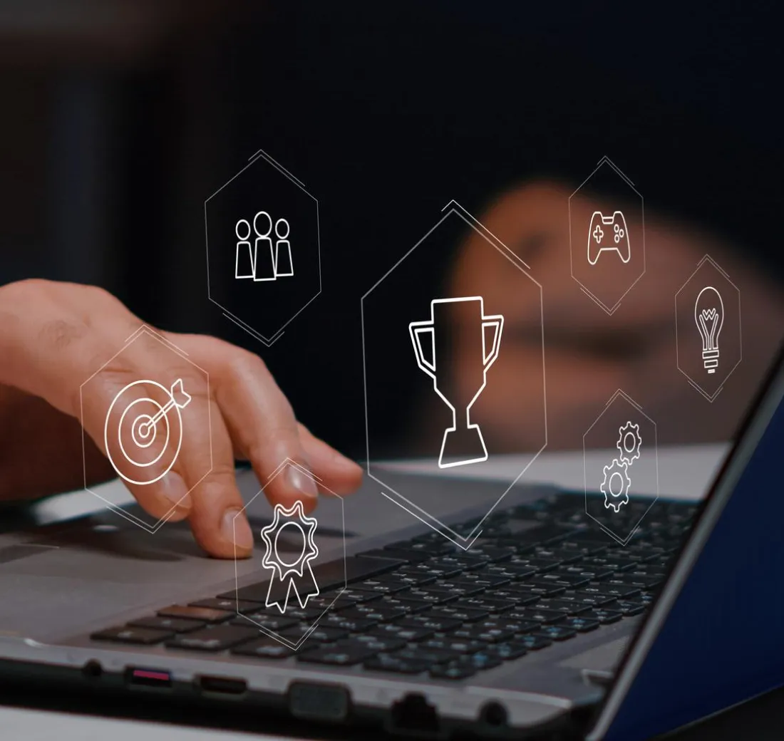 A person using a laptop with icons coming out of it.